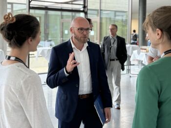 Digitalminister Dr. Mehring im Gespräch mit Rebecca Noy und Katharina Schweiger von der OmniCert. Bild: Bayerisches Staatsministerium für Digitales